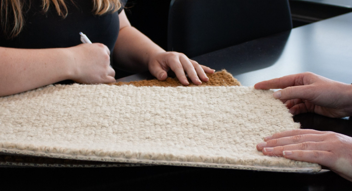 A worker from Invercargill and Winton Flooring Xtra talking to a client about installing wool carpet in their home
